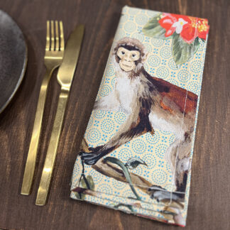 Monkey napkin on table beside knife and fork